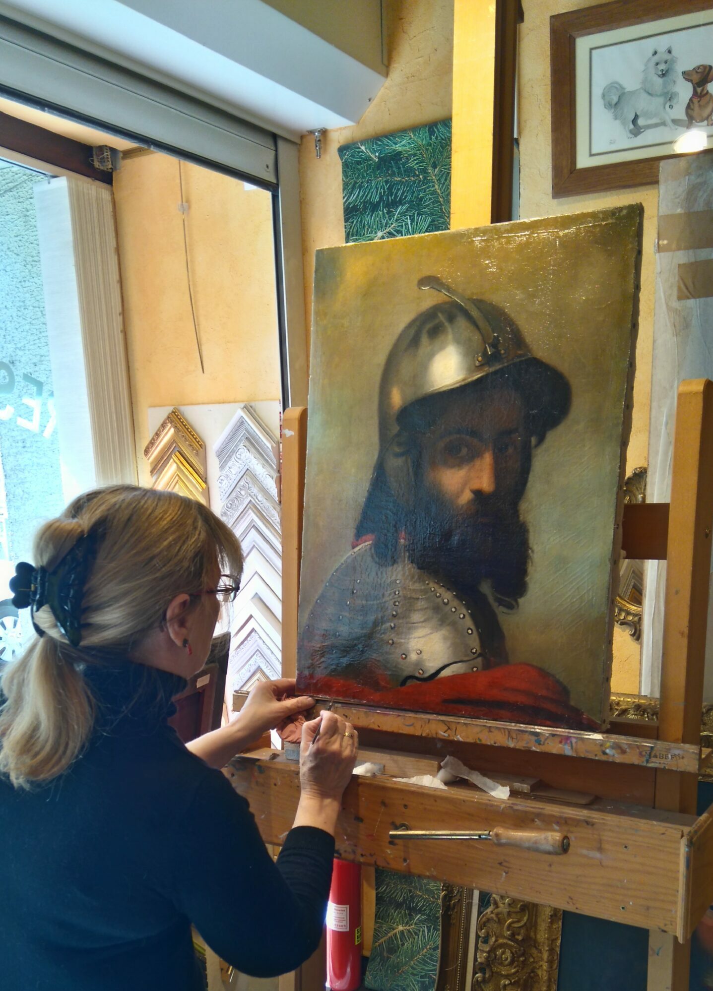 Véronique est entrain de faire des retouches de finition sur une huile sur toile d'un beau portrait de militaire (époque moyenâgeuse)