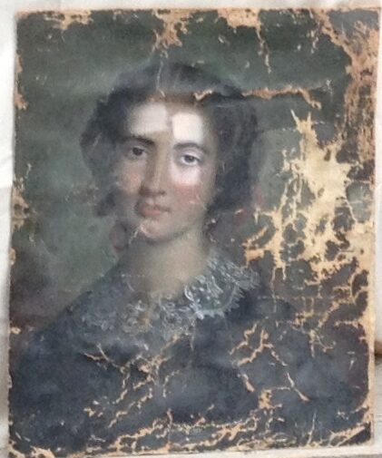 Photo d'un portrait à l'huile d'une jeune femme très détérioré posée sur un carton