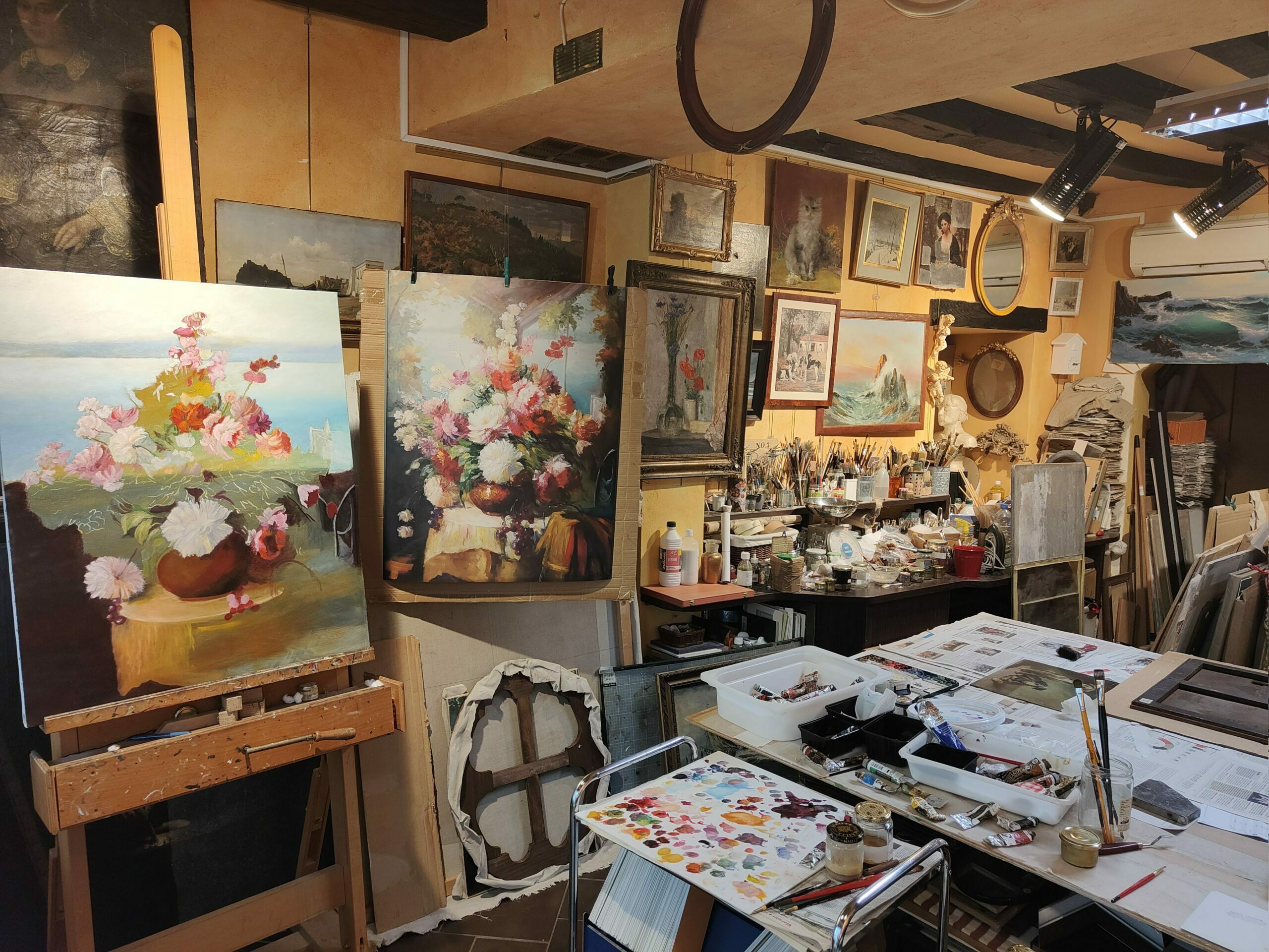 Photo de l'intérieur de l'atelier Alizarine. Une quantité impressionnante de tableaux et de pinceaux de toutes sortes